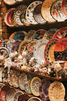 A colorful array of handcrafted ceramic plates and figurines on display in a market.