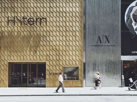 Urban shopping scene with storefronts of H. Stern and Armani Exchange, capturing pedestrians on a sunny day.