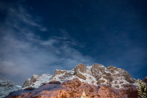 Free A breathtaking view of a snow-capped mountain at night under a clear starry sky, capturing the essence of winter. Stock Photo
