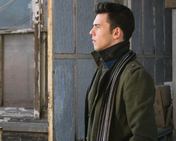 Man in dark green trench coat side profile
