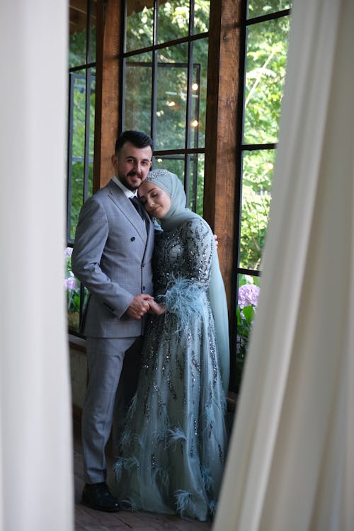 Man in Gray Suit Jacket and Woman in Blue Green Wedding Dress