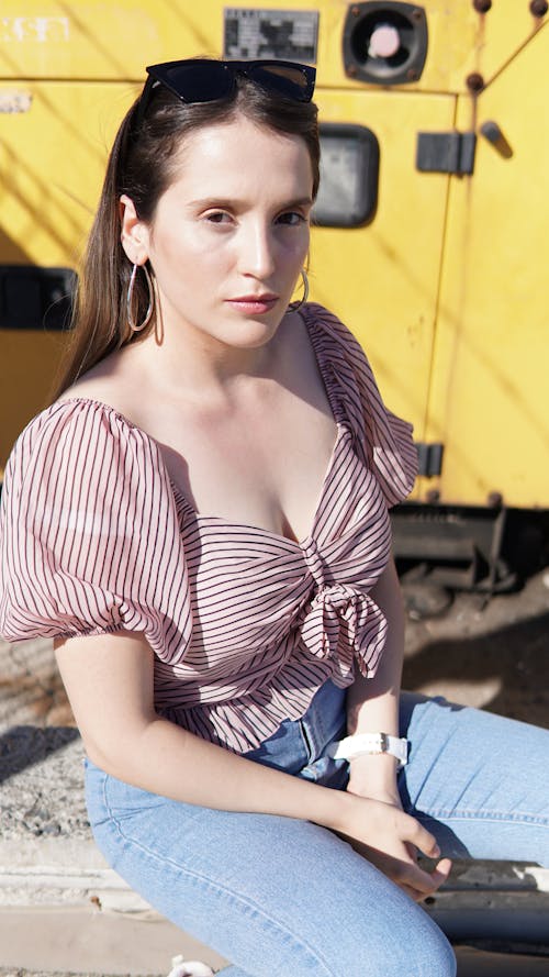 Woman Wearing Stripe Blouse Sitting on a Bench