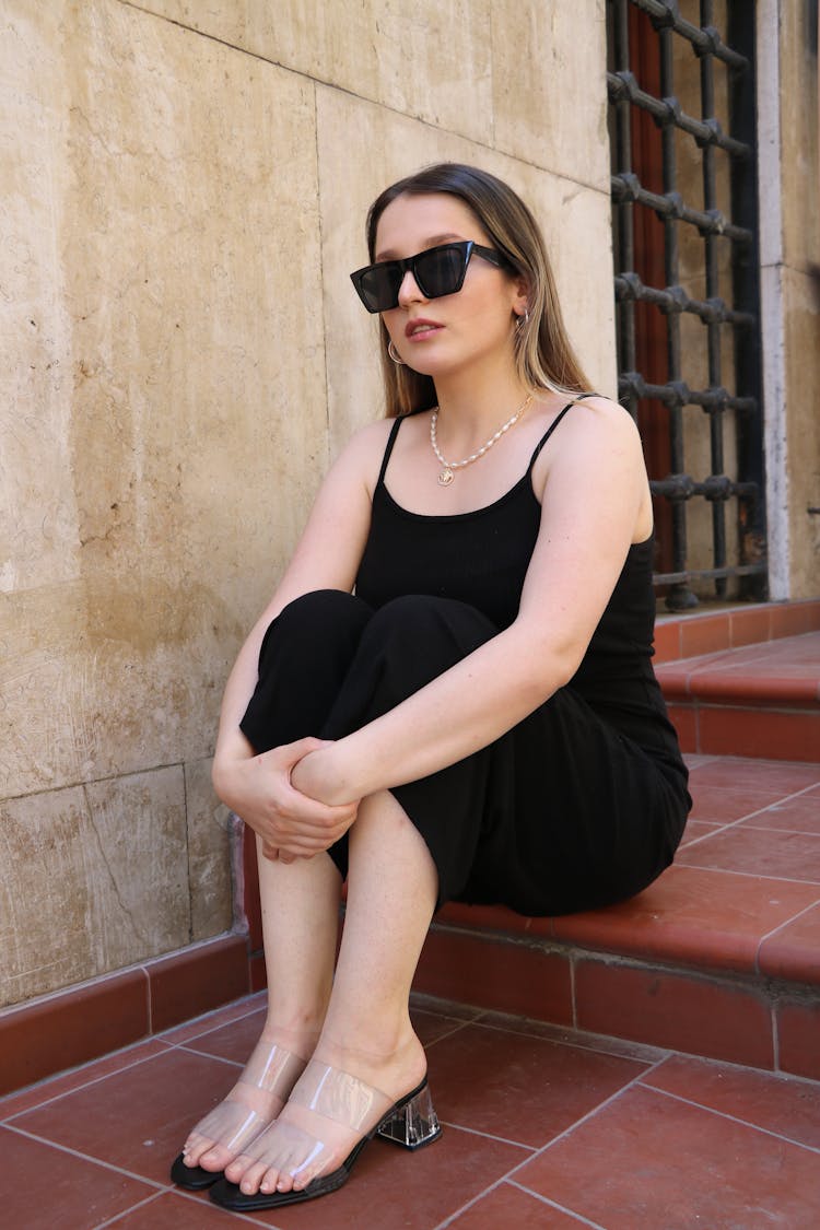 Woman In Black Tank Top Dress Sitting On The Step Of Stairs