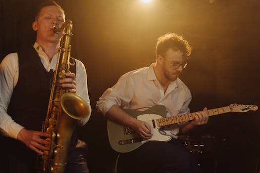 Jazz musicians performing live with saxophone and guitar under warm lighting.