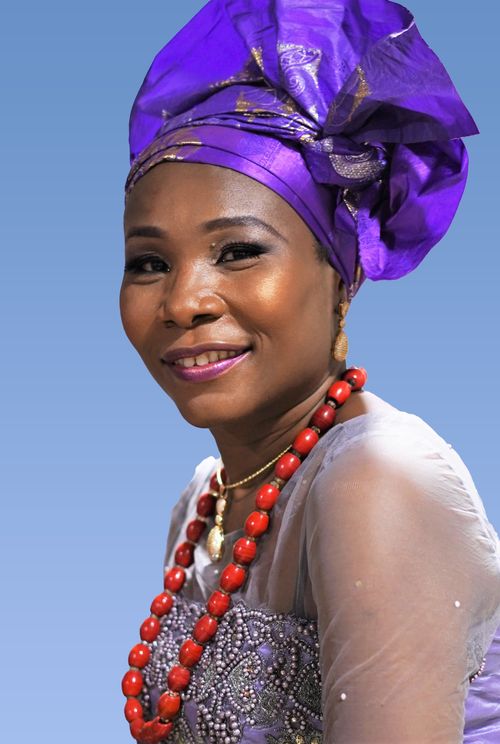 Free Capture of a woman in stunning purple traditional Nigerian attire adorned with beads and a headwrap. Stock Photo