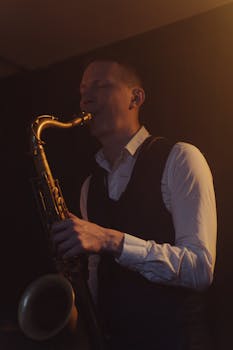 Musician playing saxophone on stage in a dimly lit jazz venue.