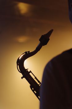 A captivating silhouette of a saxophonist highlighted by warm backlighting, evoking a jazz ambiance.