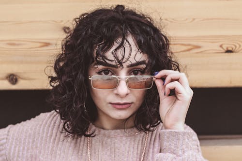 Woman in Pink Sweater Wearing Gold Framed Sunglasses