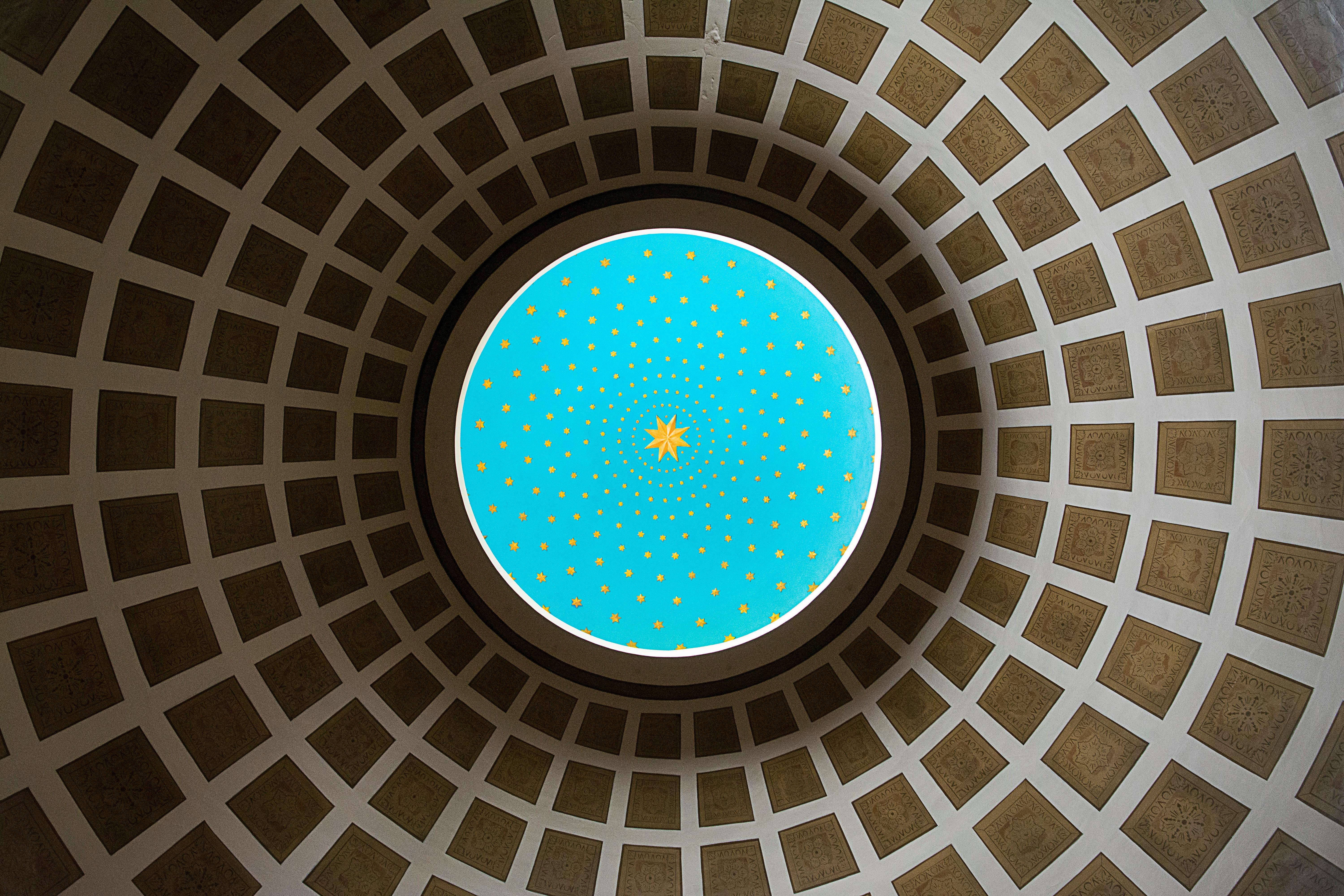 A stunning view of a colorful dome ceiling featuring intricate patterns and star shapes, located in Valencia, Spain.