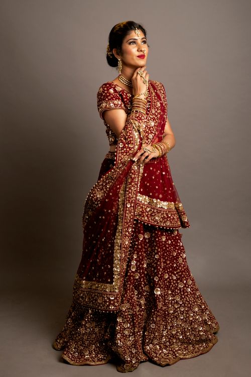 Free Portrait of an Indian woman in bridal dress against a grey background, showcasing elegance. Stock Photo
