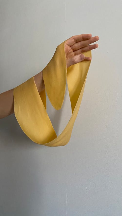 Close-Up Shot of a Person Holding a Yellow Ribbon 