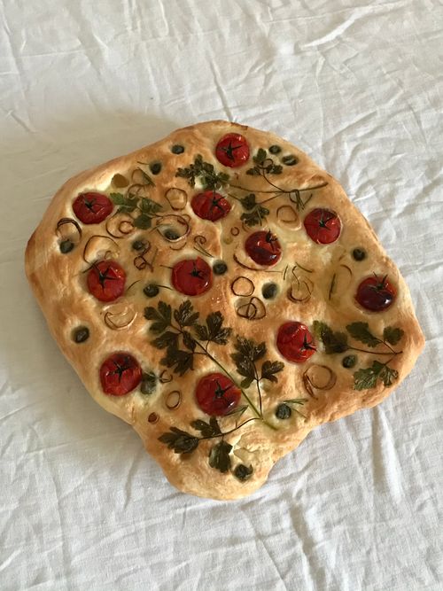 Free Delicious homemade focaccia bread topped with fresh tomatoes and herbs. Stock Photo