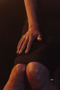 Person in Black Skirt Sitting on Black Textile