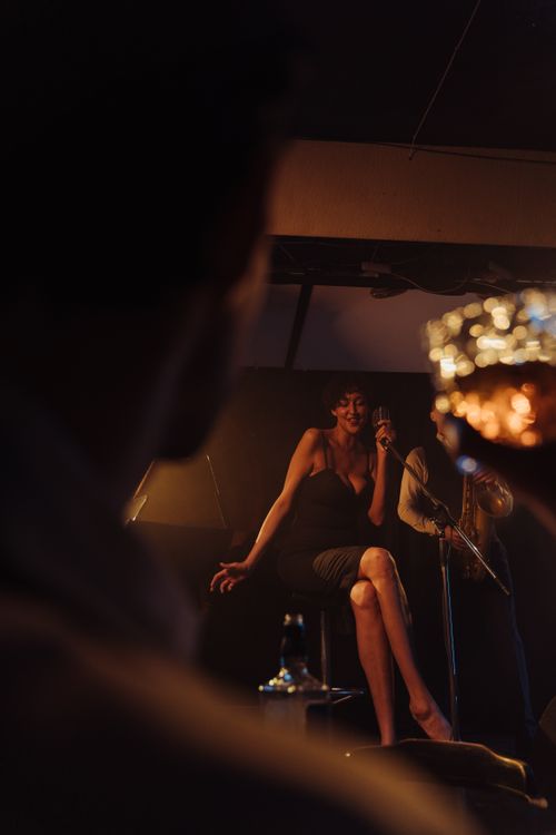 Free A jazz singer performing on stage with a saxophonist, creating a vibrant nightlife mood. Stock Photo