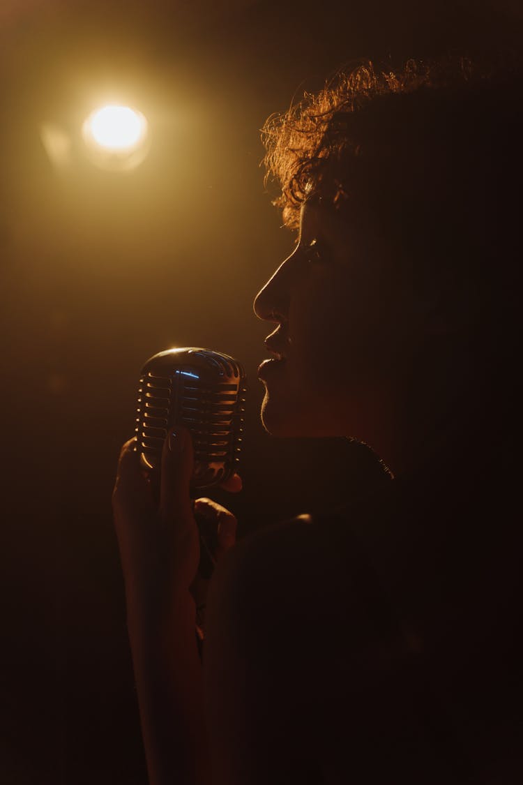 Photograph Of A Woman Singing With A Microphone