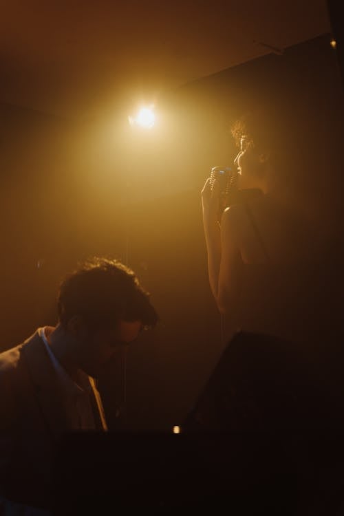 Photo of a Woman Singing Near a Man