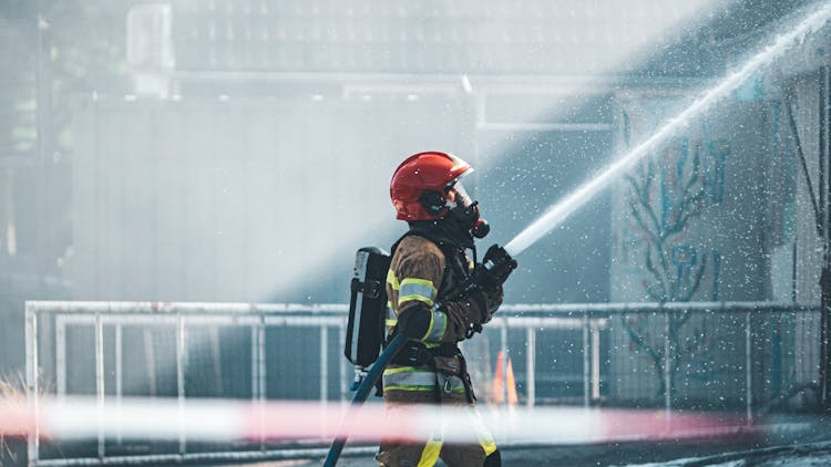 Photo Of A Fireman Holding A Fire Hose