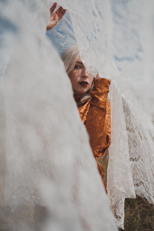 Free A Woman Behind a White Lace Curtain Stock Photo