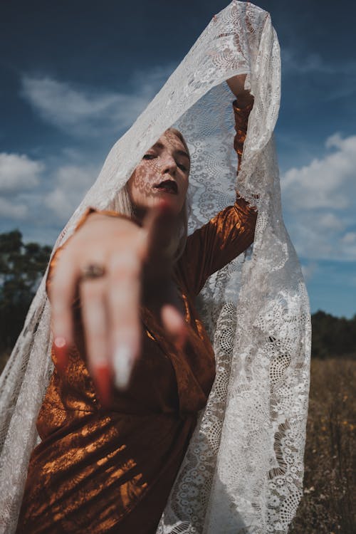 A Woman Pointing Her Finger while Holding a White Scarf