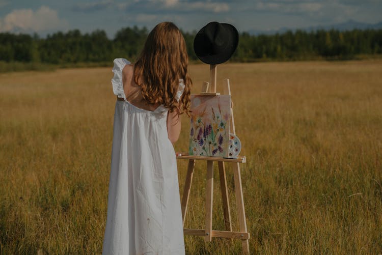 Woman In White Dress Painting In The Field