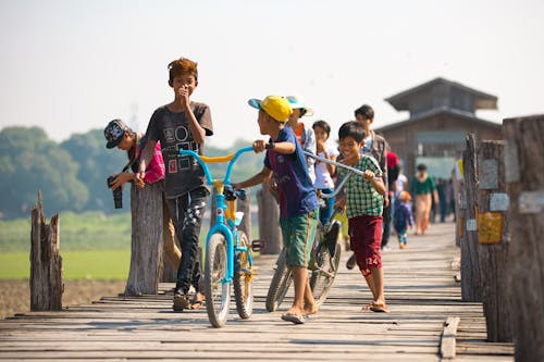 Photograph of Kids Walking  with Their Bikes 