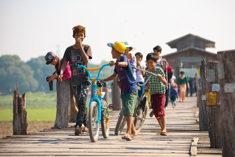 Photograph Of Kids Walking  With Their Bikes 