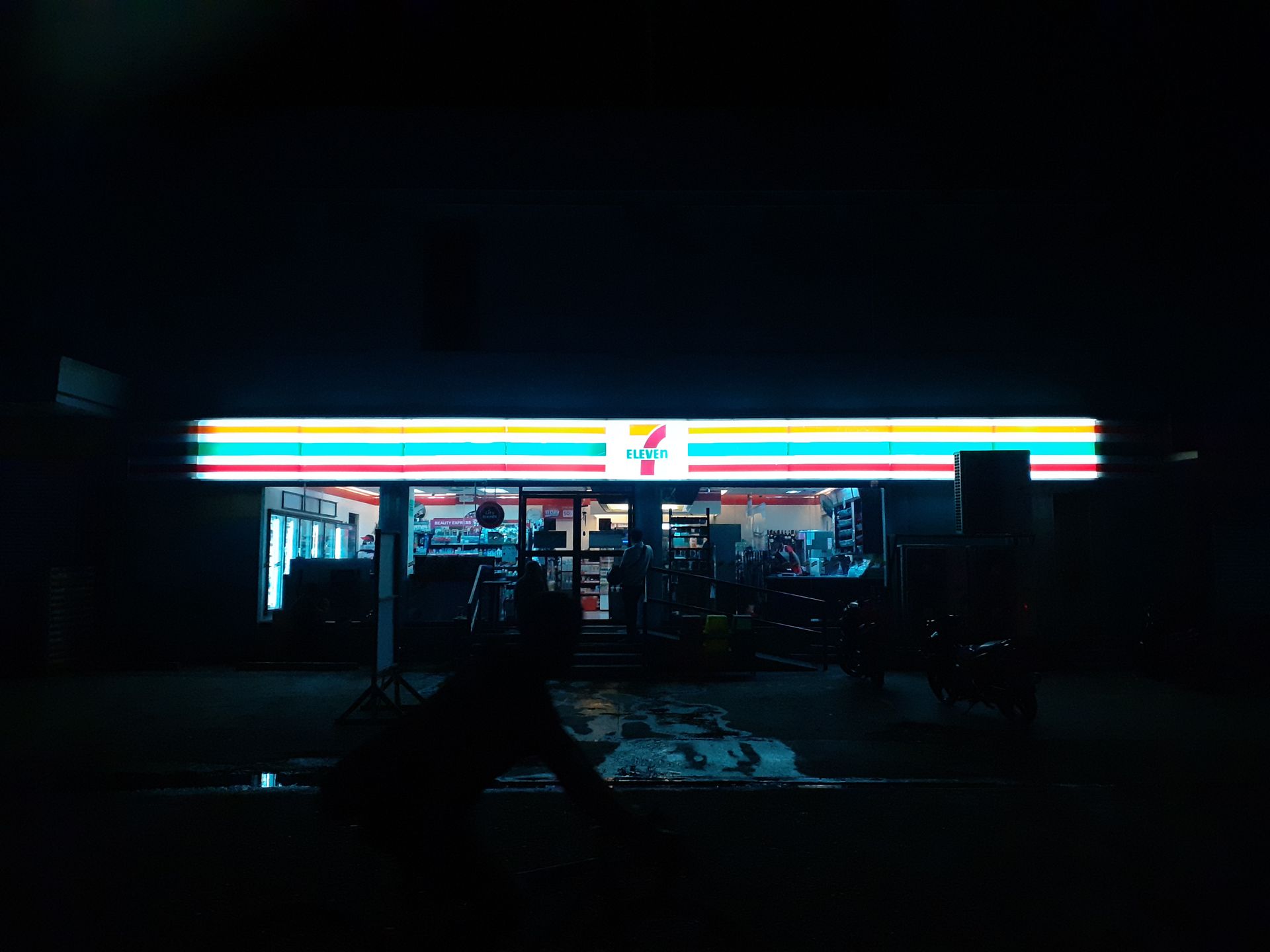 Night scene of a brightly lit convenience store in Naga City, Philippines.