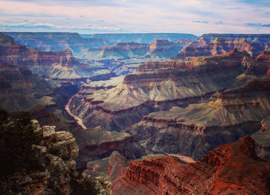 45-minute Helicopter Flight Over the Grand Canyon from Tusayan, Arizona - Stunning aerial view of the Grand Canyon showcasing the deep valleys and rugged landscape under a colorful sky.
