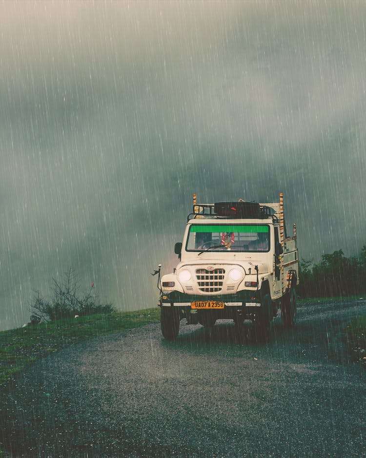 A White Car Moving On The Road While Raining