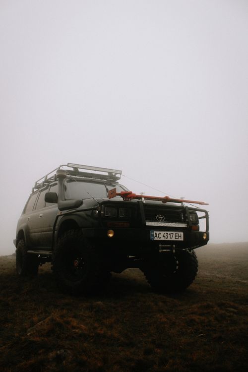 Free Toyota Land Cruiser SUV on a foggy landscape, perfect for off-road enthusiasts. Stock Photo