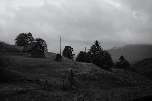 Grayscale Photo of House on a Hill 