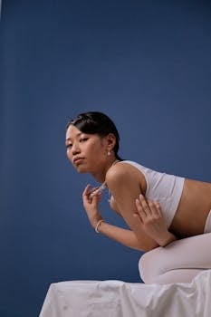 Graceful pose of a woman wearing pearl jewelry against a blue backdrop.