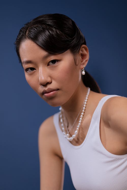 Free Woman in White Tank Top Wearing White Necklace and Earrings Stock Photo