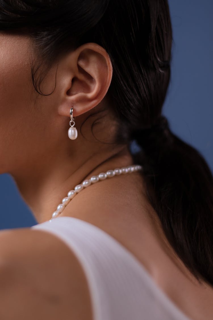 Person In White Tank Top Wearing White Pearl Necklace