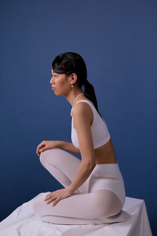 A Woman Sitting wearing White Leggings 