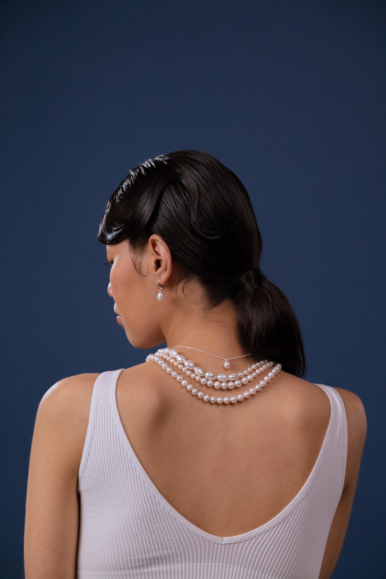 A Woman Wearing Pearl Necklace And Earing 