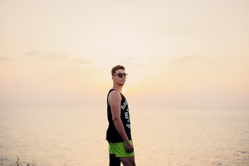 Man in Black Tank Top and Neon Green Shorts