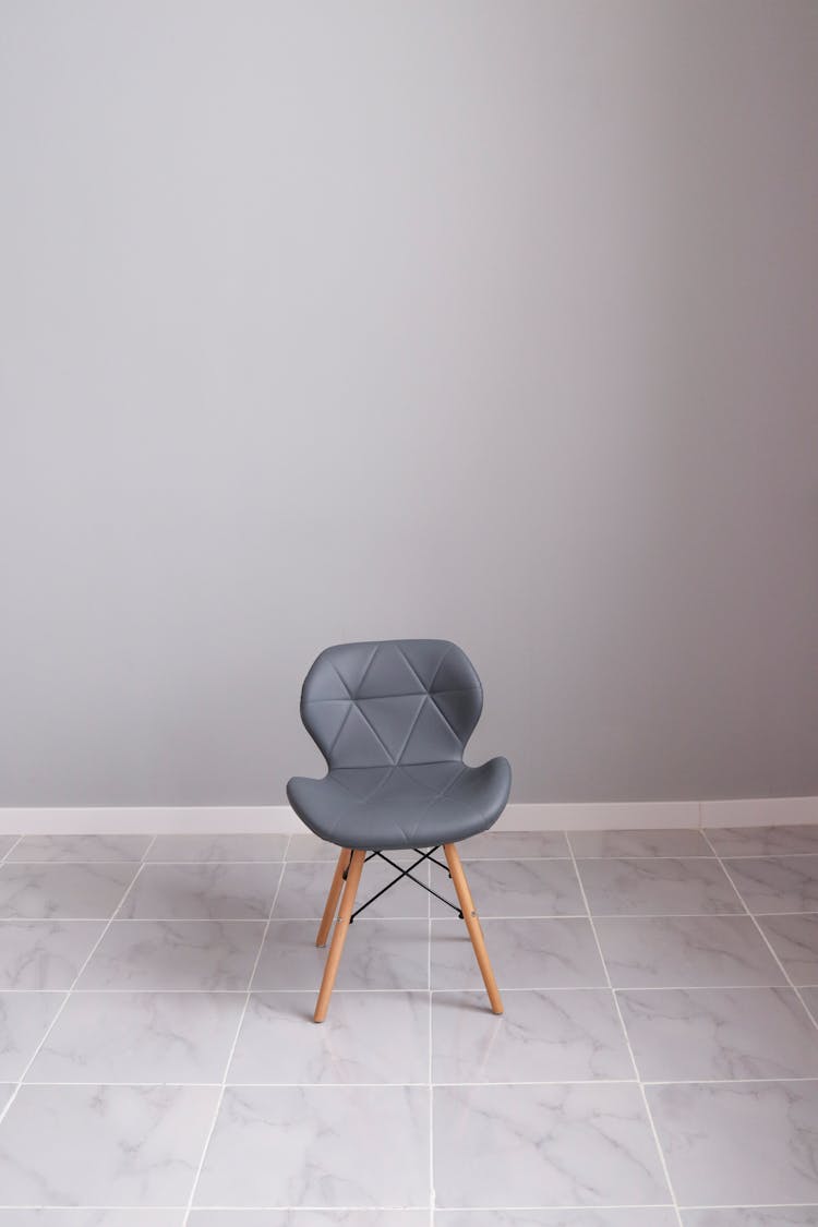 Gray Chair With Wooden Legs On Gray Floor Tiles