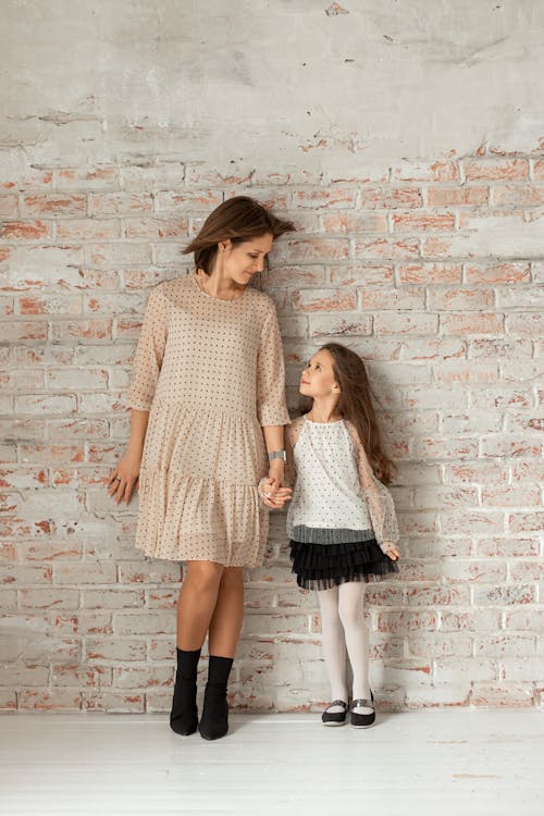 Woman and Child Leaning on Brick Wall