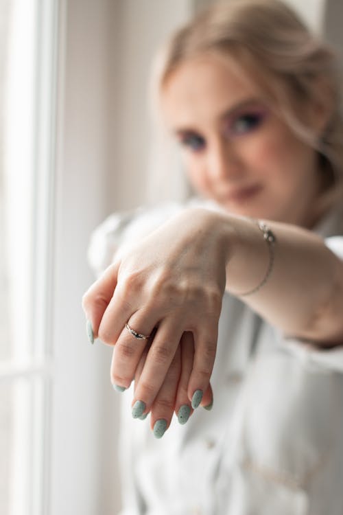 Selective Focus Photo of a Woman's Hands with a Ring