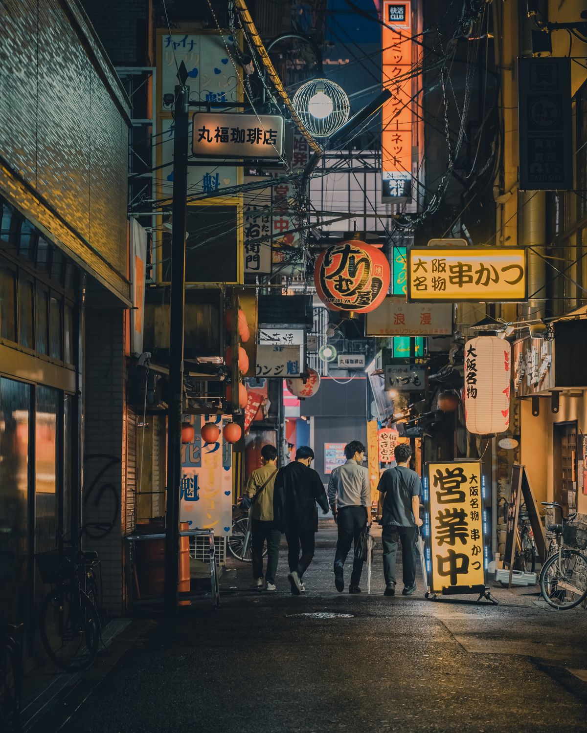 Friends walking through a lively Japanese street at night