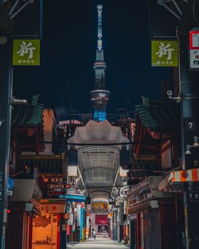 Vibrant street scene with Tsūtenkaku Tower in Osaka, Japan, beautifully illuminated at night.
