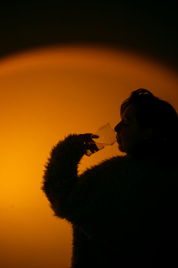 Silhouette Of A Woman Drinking Beverage