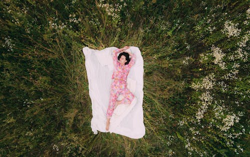 Free Woman Lying on Blanket in the Field Stock Photo