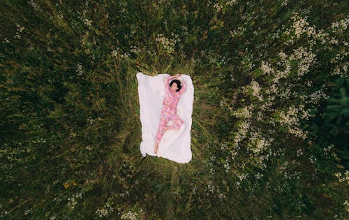 Drone Shot of a Woman Lying on Blanket in the Field