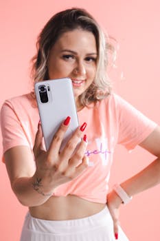 Smiling woman taking a selfie with a smartphone, showcasing a modern lifestyle.