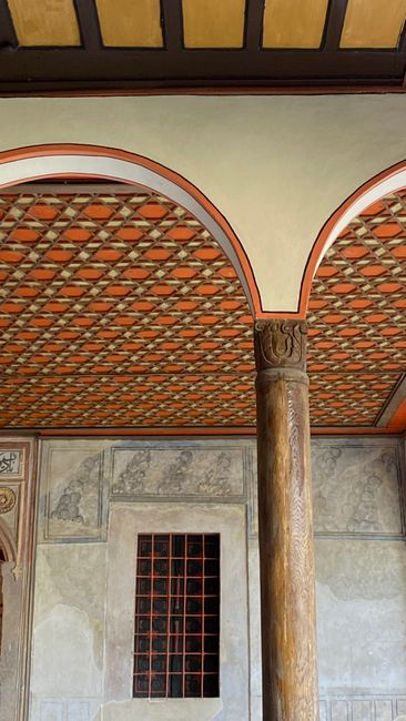 Detailed view of an ornate interior with arches, columns, and decorative ceiling.