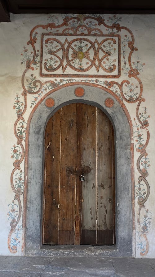 Brown Wooden Door on  Concrete Wall with Floral Design