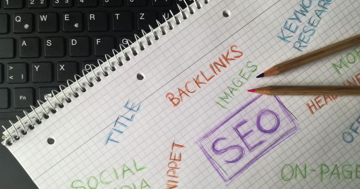 Close-up of a notebook with SEO and marketing terms on a desk.
