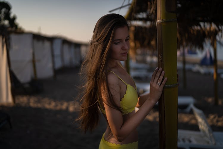 Woman In Yellow Bikini Near Brown Wooden Post